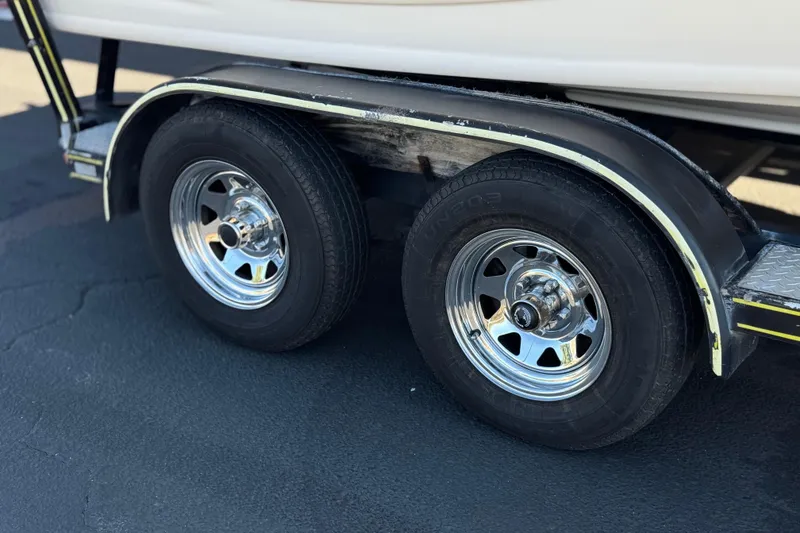Slide: The Image of Trailer wheels of a 2003 Rinker 192 Captiva Bowrider on pavement. - 25