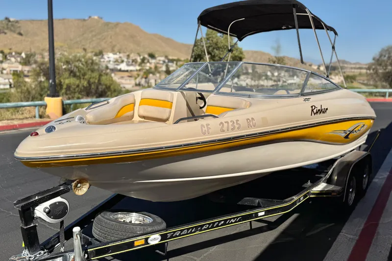 Slide: The Image of 2003 Rinker 192 Captiva Bowrider boat on trailer, parked outdoors with scenic background. - 3