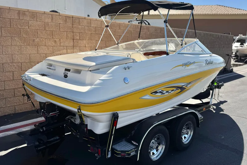 Slide: The Image of 2003 Rinker 192 Captiva Bowrider boat on trailer, featuring yellow and white design. - 5