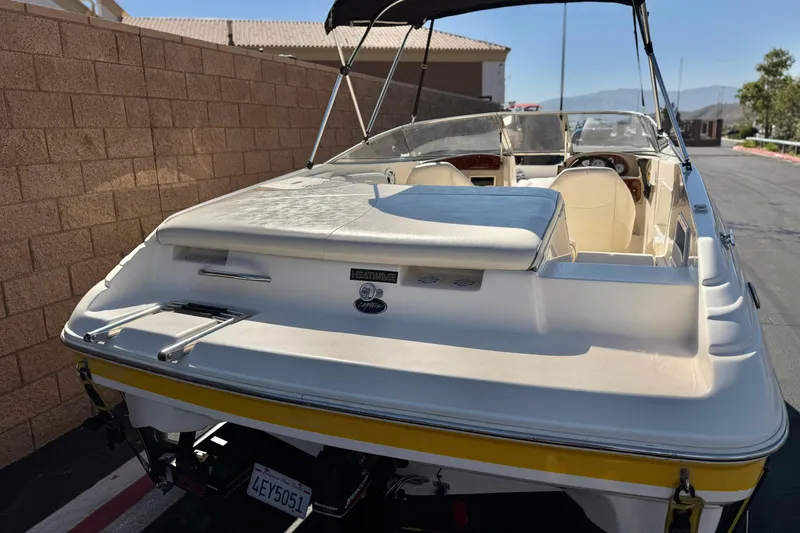 Slide: The Image of 2003 Rinker 192 Captiva Bowrider boat parked, showcasing rear seating and sleek design. - 6