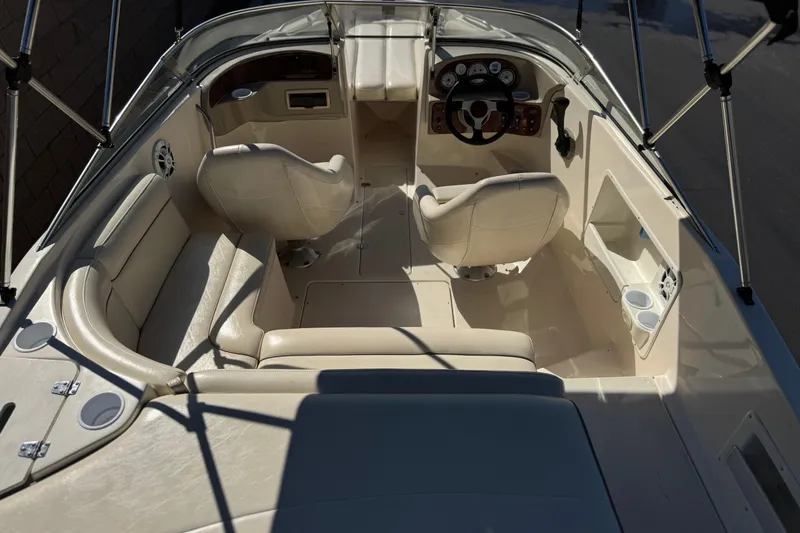 Slide: The Image of 2003 Rinker 192 Captiva Bowrider interior with beige seating and steering console. - 8