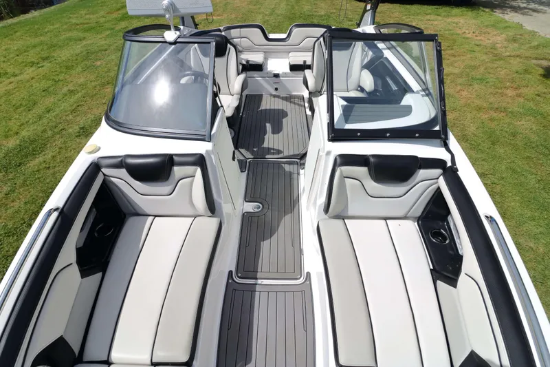 Slide: The Image of 2017 Yamaha Boats 212X interior with sleek seating and modern design on grassy background. - 11