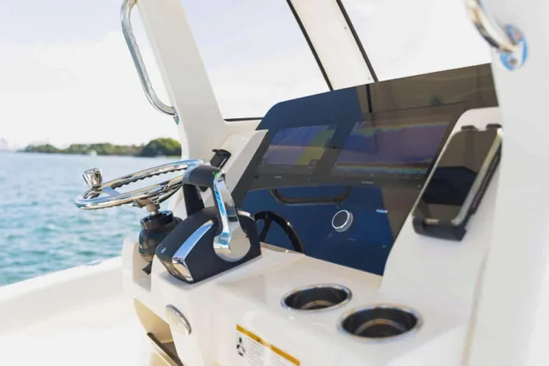 Slide: The Image of Manufacturer Provided Image: 2025 Scout 260 LXF boat dashboard with steering wheel and controls, on open water. - 6