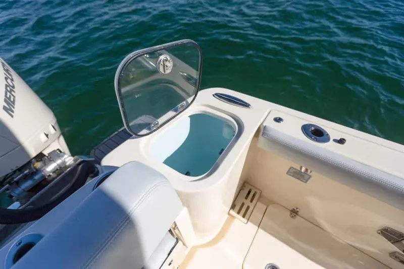 Slide: The Image of Manufacturer Provided Image: 2025 Scout 260 LXF boat with open storage compartment on deck, near water. - 8