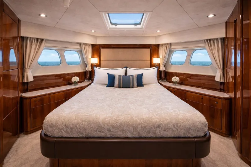Slide: The Image of Luxurious bedroom interior of a 2014 Azimut 48 yacht, featuring elegant wood finishes and ocean views. - 11