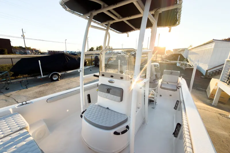 Slide: The Image of 2026 Carolina Skiff 19 LS boat interior with seating and console, sunlit in a marina setting. - 12
