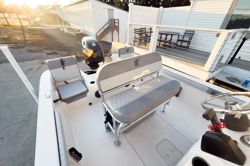 Slide: The Image of 2026 Carolina Skiff 19 LS boat interior with seating and steering wheel in sunlight. - 21