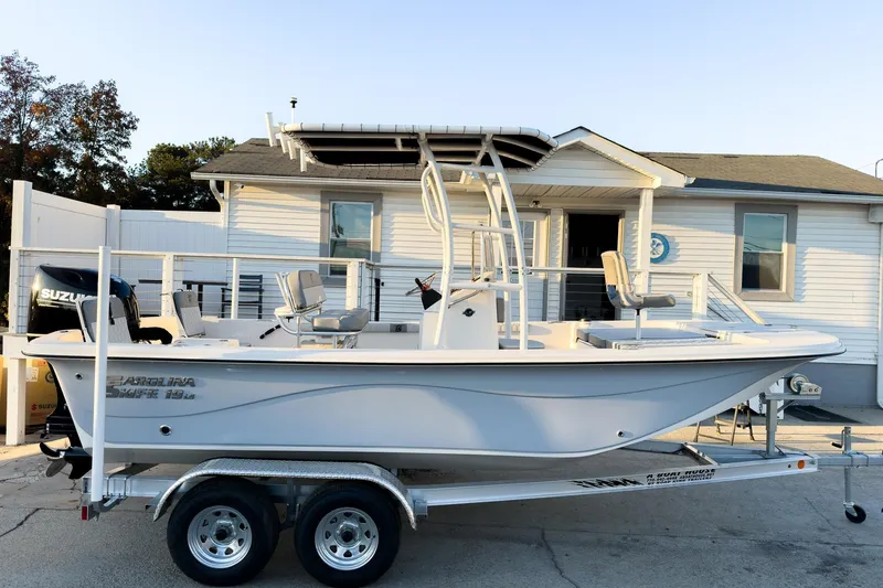 Slide: The Image of 2026 Carolina Skiff 19 LS boat on trailer, parked outside a house. - 7