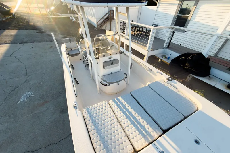 Slide: The Image of 2026 Carolina Skiff 19 LS boat with spacious deck and seating, docked in sunlight. - 9