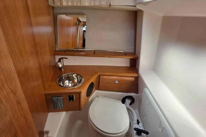 Slide: The Image of 2026 Cutwater C-248 Coupe bathroom with wooden cabinetry, sink, and toilet. - 12