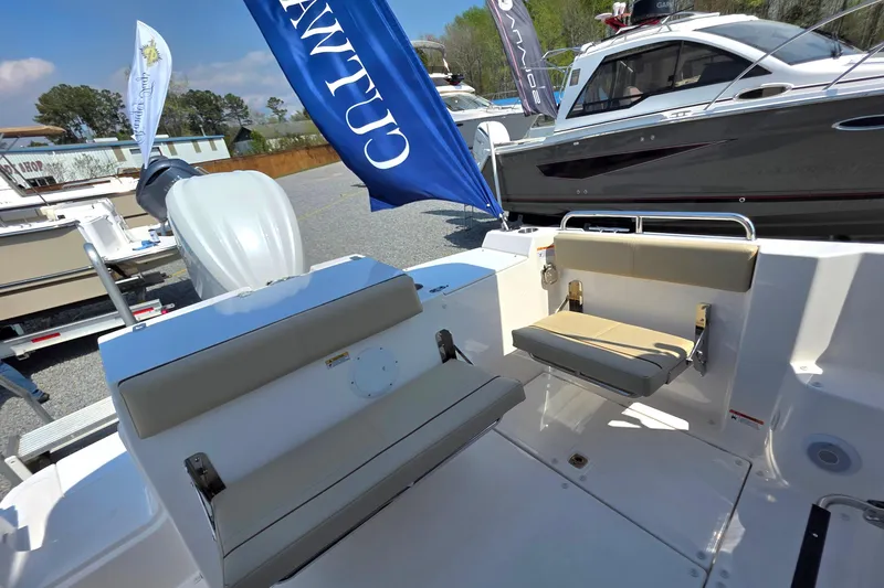 Slide: The Image of 2026 Cutwater C-248 Coupe boat interior with seating and outboard motor, displayed outdoors. - 15