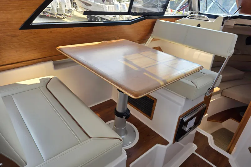 Slide: The Image of Interior of 2026 Cutwater C-248 Coupe featuring a wooden table and cushioned seating. - 8