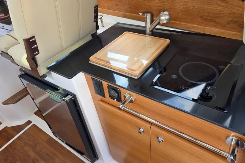 Slide: The Image of 2026 Cutwater C-248 Coupe interior kitchen with stove, sink, and cutting board. - 9