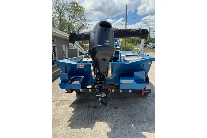 Slide: The Image of 2026 SeaArk Shadow 187T boat with outboard motor, parked outdoors. - 3