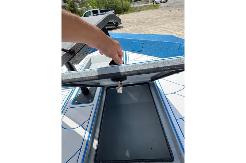 Slide: The Image of Hand opening storage compartment on 2026 SeaArk Shadow 187T boat deck. - 9