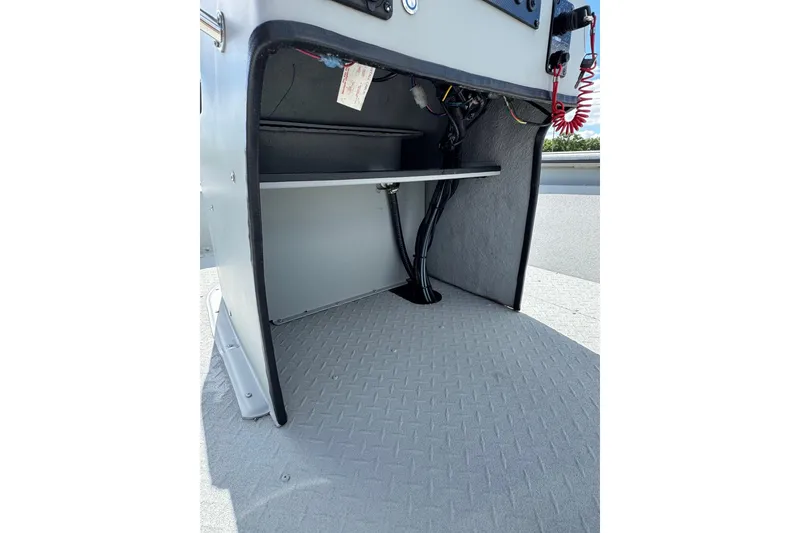 Slide: The Image of Interior view of 2025 SeaArk Shadow 18T boat console with wiring and storage space. - 10