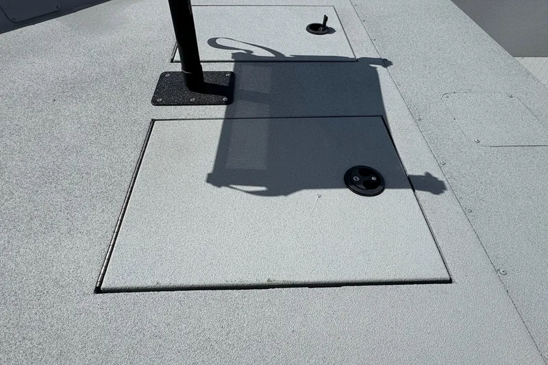 Slide: The Image of 2025 SeaArk Shadow 18T boat deck with storage hatch and pole mount. - 12