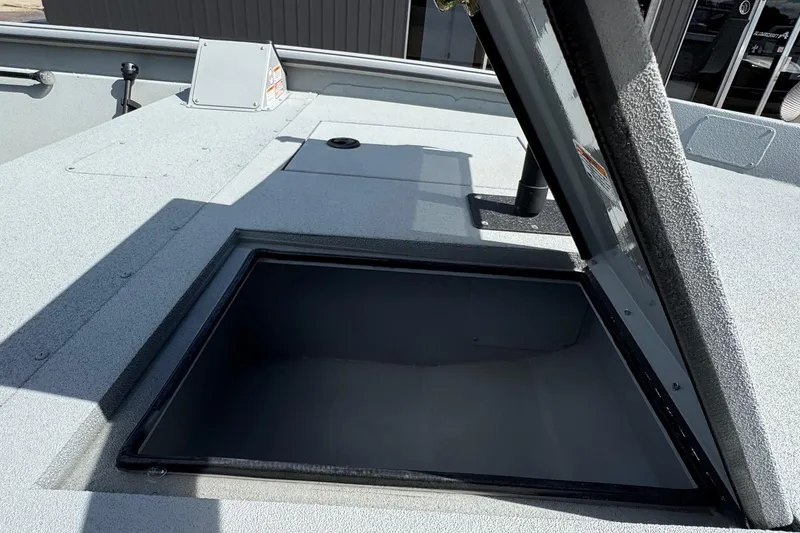 Slide: The Image of Open storage compartment on 2025 SeaArk Shadow 18T boat deck. - 13