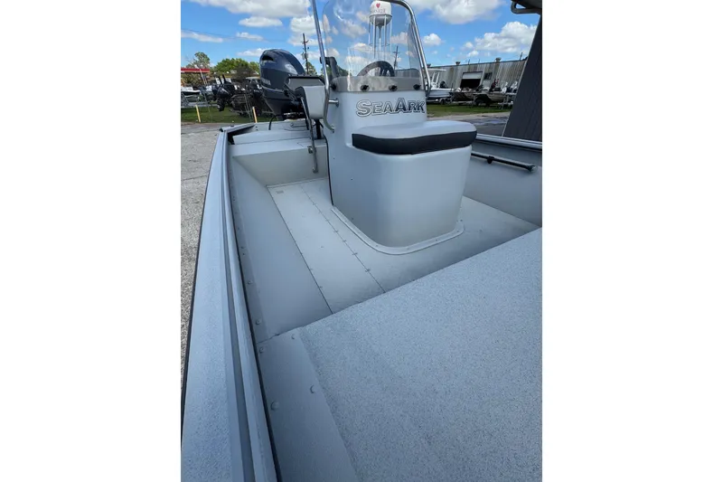 Slide: The Image of 2025 SeaArk Shadow 18T boat interior with console and seating, under a clear blue sky. - 17