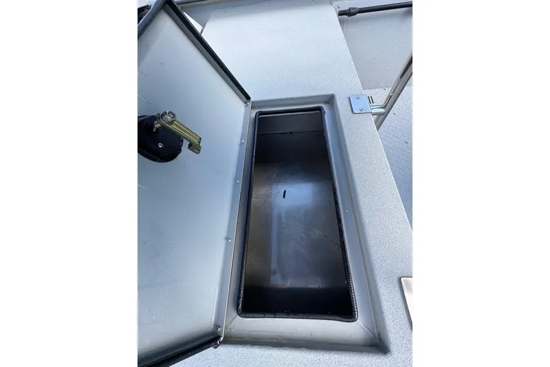 Slide: The Image of Open storage compartment on 2025 SeaArk Shadow 18T boat deck. - 19