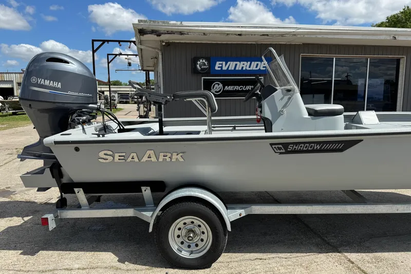 Slide: The Image of 2025 SeaArk Shadow 18T boat with Yamaha engine, parked outside dealership. - 2