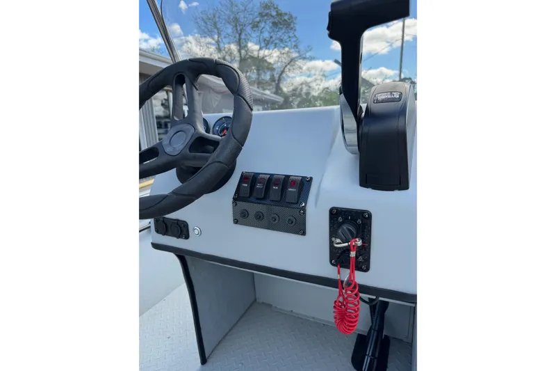 Slide: The Image of 2025 SeaArk Shadow 18T boat dashboard with steering wheel and control panel. - 20