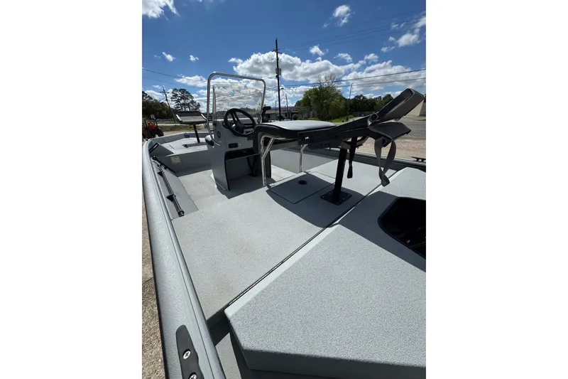 Slide: The Image of 2025 SeaArk Shadow 18T boat interior with steering console and seating under a clear sky. - 9