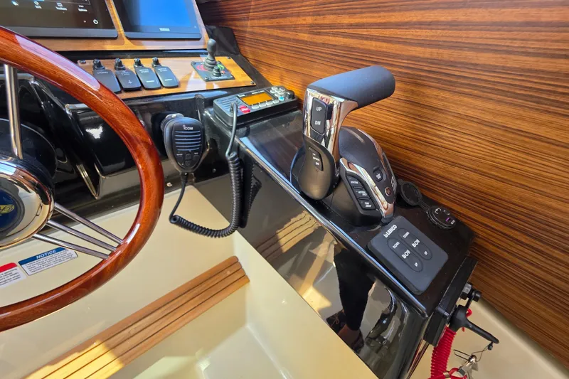 Slide: The Image of 2026 Ranger Tugs R-27 helm with wood accents and modern controls. - 15