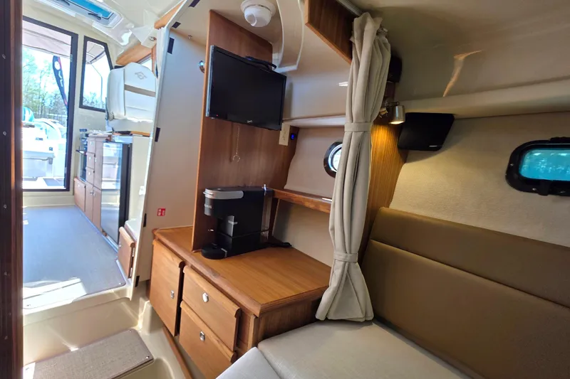 Slide: The Image of Interior of 2026 Ranger Tugs R-27, featuring cozy seating, kitchenette, and modern amenities. - 17