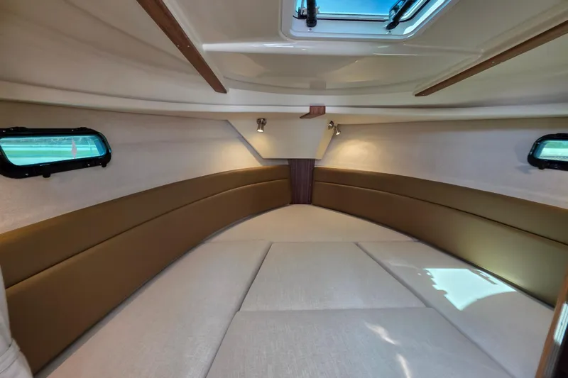 Slide: The Image of 2026 Ranger Tugs R-27 cabin interior with cozy seating and natural light. - 19