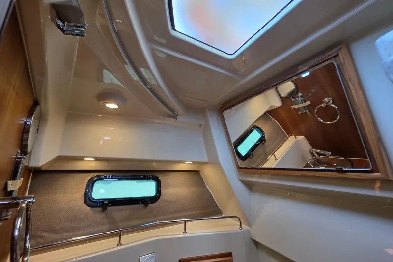 Slide: The Image of 2026 Ranger Tugs R-27 interior cabin with mirror, window, and modern lighting. - 21