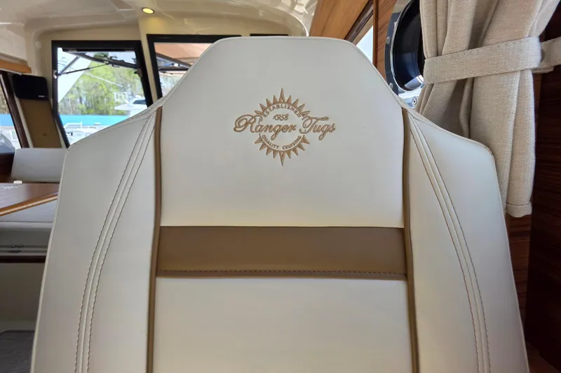 Slide: The Image of Captain's seat in 2026 Ranger Tugs R-27 boat, featuring embroidered logo. - 24