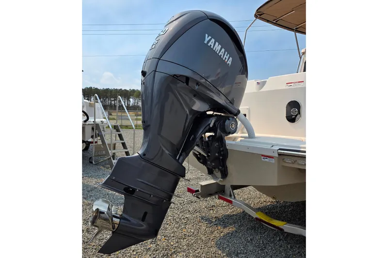 Slide: The Image of 2026 Ranger Tugs R-27 with Yamaha outboard motor, parked on gravel. - 3