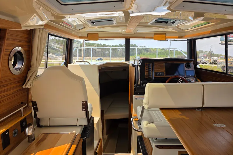 Slide: The Image of Interior of 2026 Ranger Tugs R-27 boat, featuring modern helm and seating area. - 8