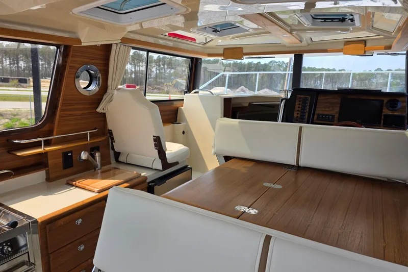 Slide: The Image of Interior of 2026 Ranger Tugs R-27 boat with wood accents and modern seating. - 9