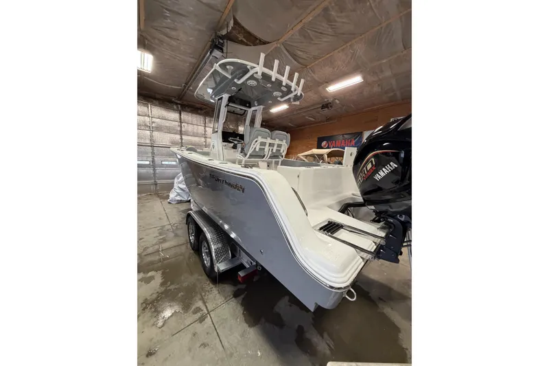 Slide: The Image of 2026 Sportsman Open 232 Center Console boat in a garage with Yamaha engine. - 1