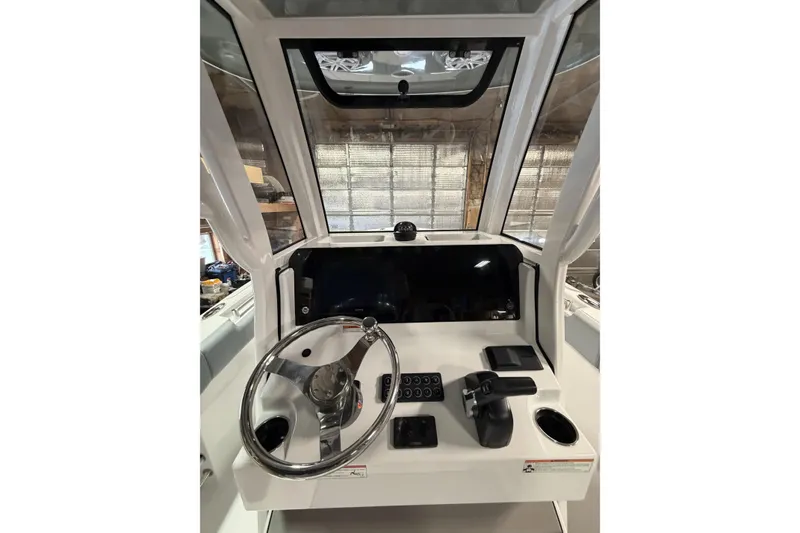 Slide: The Image of 2026 Sportsman Open 232 Center Console boat dashboard with steering wheel and controls. - 10