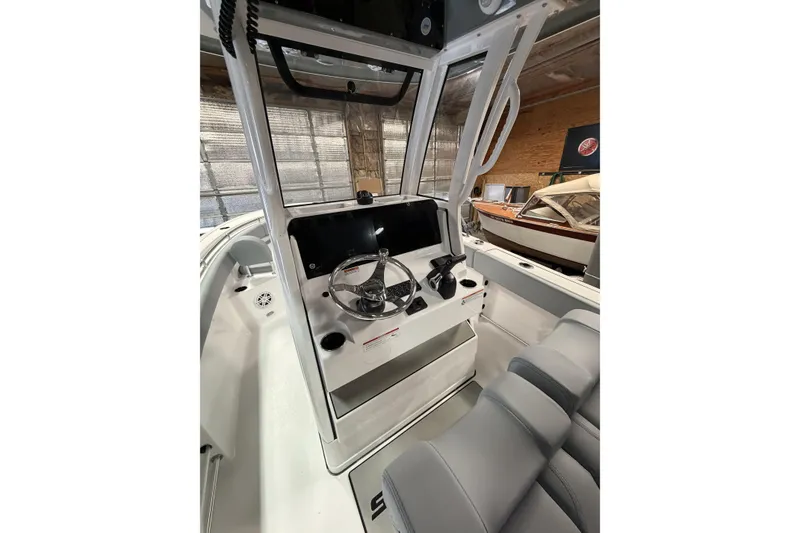 Slide: The Image of 2026 Sportsman Open 232 Center Console boat interior with steering wheel and seating. - 11