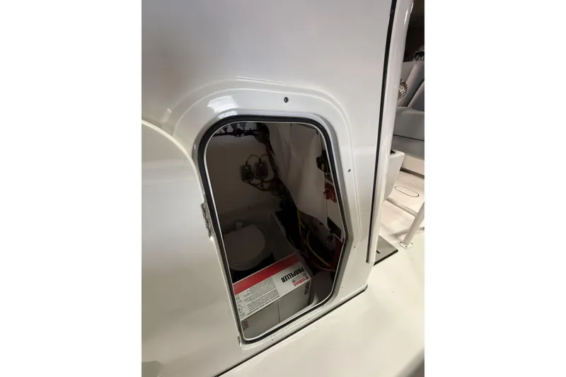 Slide: The Image of 2026 Sportsman Open 232 Center Console storage compartment with battery and wiring. - 15