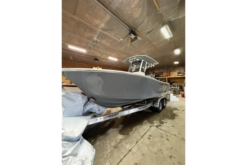 Slide: The Image of 2026 Sportsman Open 232 Center Console boat on trailer in a garage. - 2