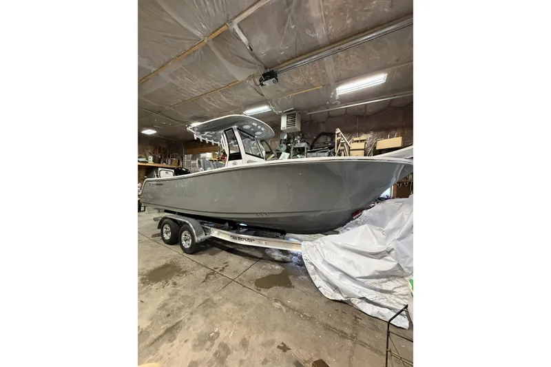Slide: The Image of 2026 Sportsman Open 232 Center Console boat on trailer in a garage. - 3