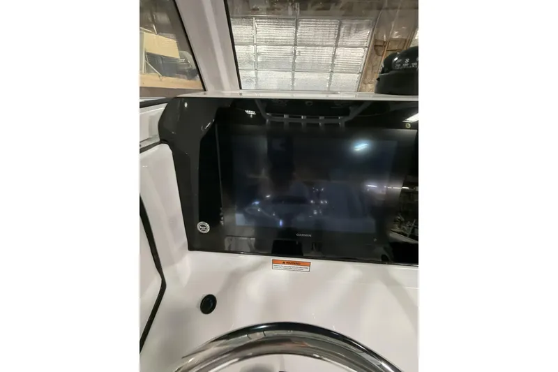 Slide: The Image of 2026 Sportsman Open 232 Center Console dashboard with Garmin display in a boat interior. - 9