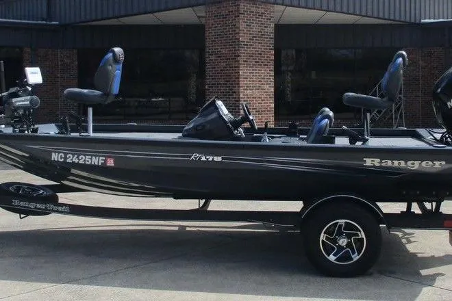 The Image of 2023 Ranger RT178 fishing boat on trailer, parked outside a brick building. - 0