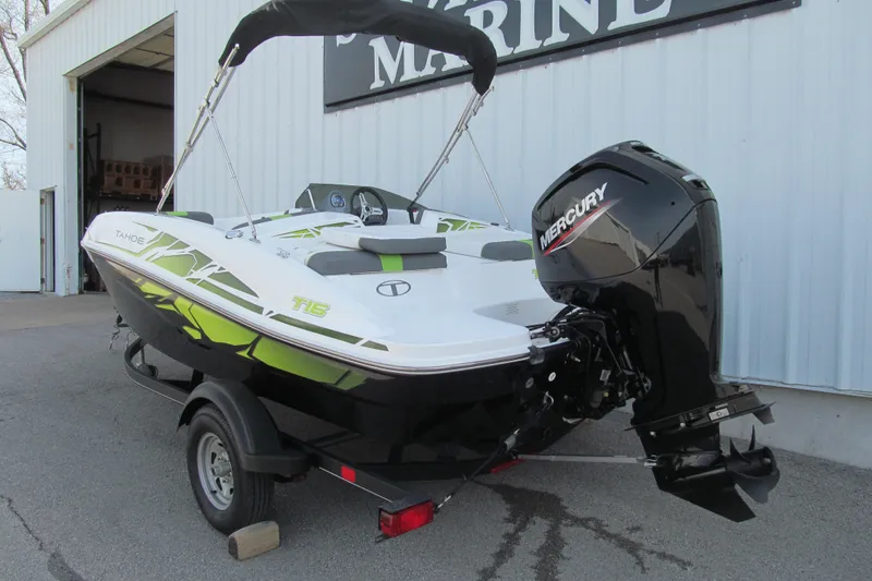 Slide: The Image of 2022 Tahoe T16 boat with Mercury outboard motor on trailer, parked outside a marine shop. - 2