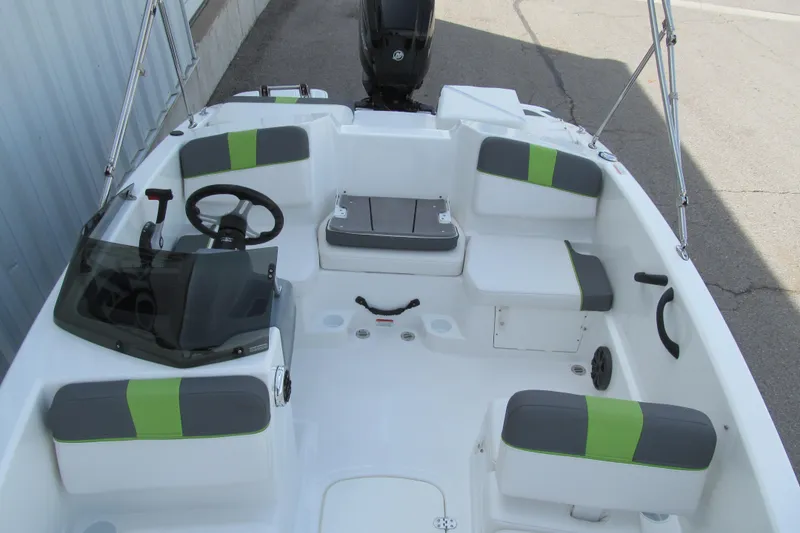 Slide: The Image of 2022 Tahoe T16 boat interior with gray and green seating, steering wheel, and console. - 9
