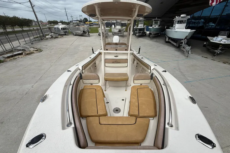 Slide: The Image of 2023 SeaChaser 24 HFC boat with tan seating, displayed outdoors at a dealership. - 10