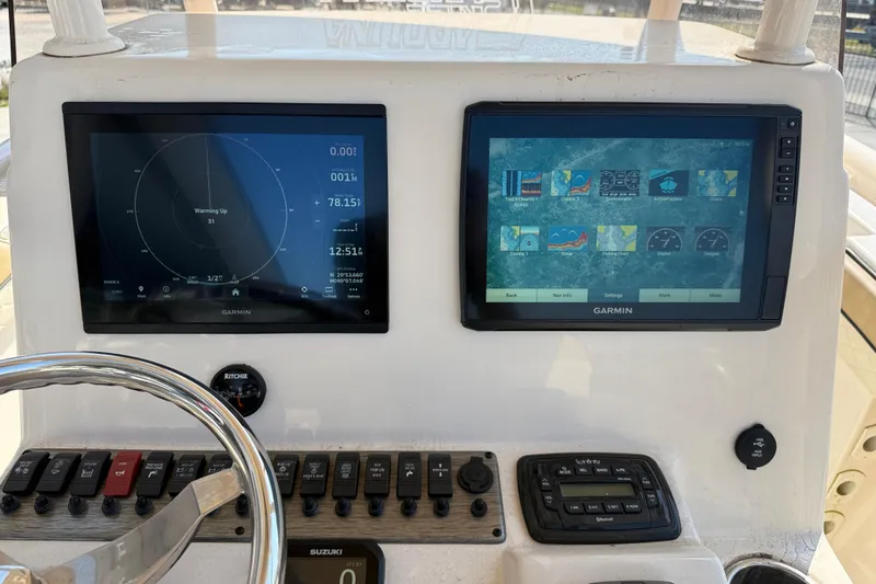 Slide: The Image of 2023 SeaChaser 24 HFC boat dashboard with dual Garmin displays and control panel. - 15
