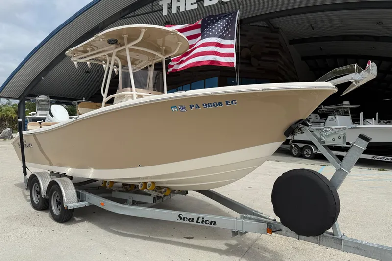 Slide: The Image of 2023 SeaChaser 24 HFC boat on trailer, American flag in background. - 2