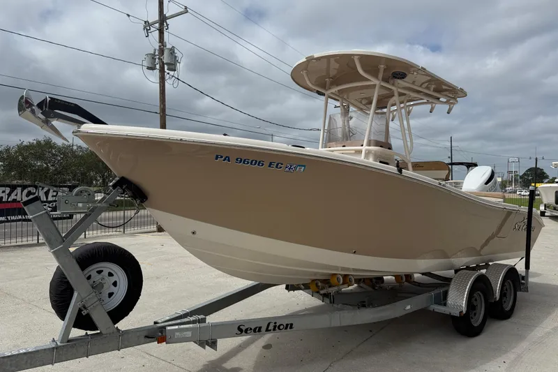 Slide: The Image of 2023 SeaChaser 24 HFC boat on trailer, parked outdoors under cloudy sky. - 3