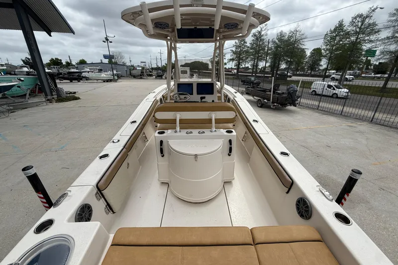 Slide: The Image of 2023 SeaChaser 24 HFC boat interior with seating and console, docked outdoors. - 7